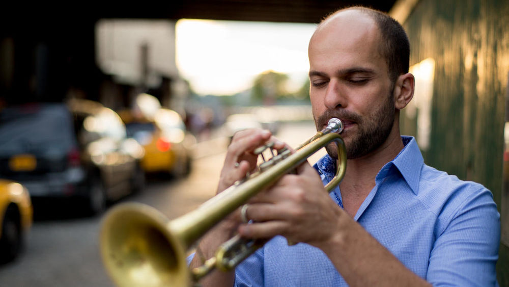 A person plays the trumpet.
