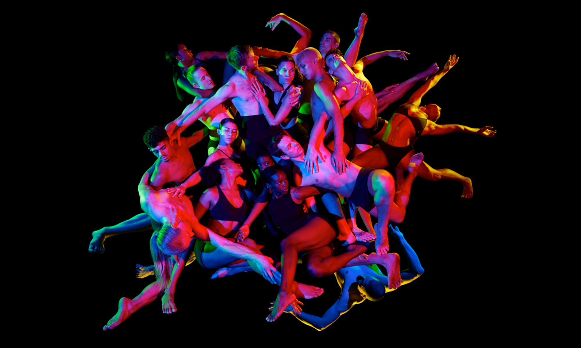 A group of dancers in colorful lighting.